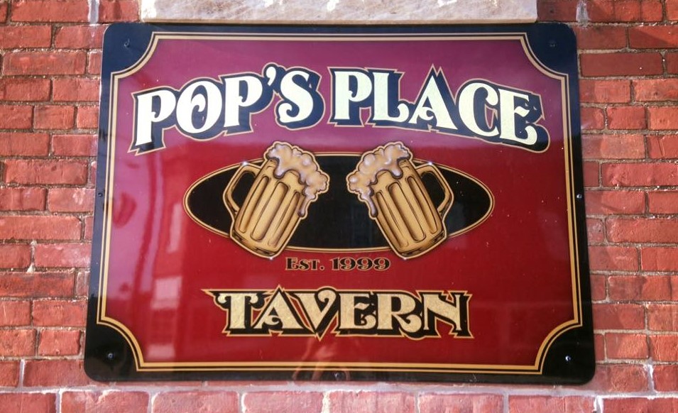 Tavern sign on a brick wall with the words for Pop's Place